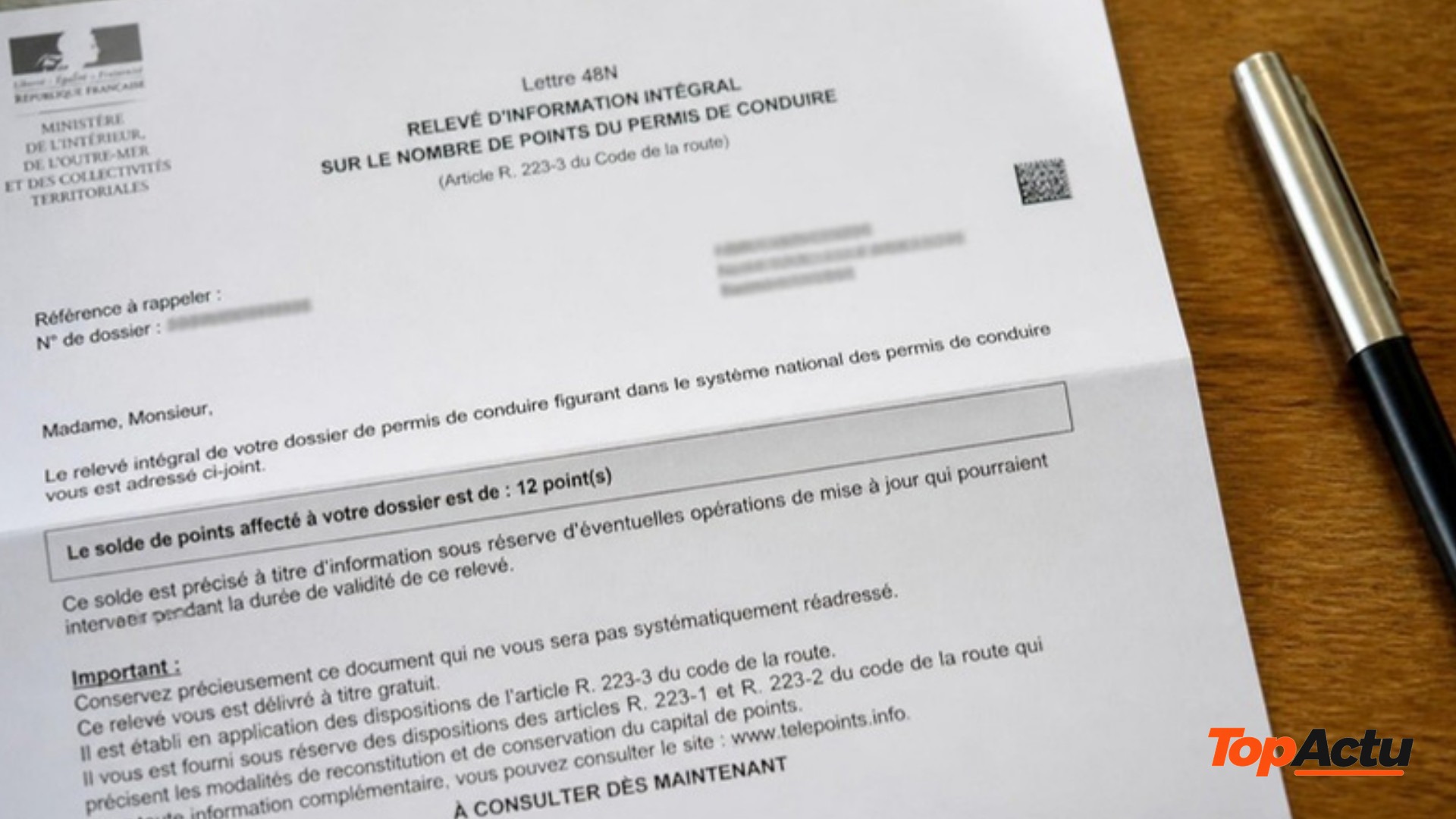 Une lettre administrative officielle au sujet du permis de conduire posée sur une table, à côté d'un stylo