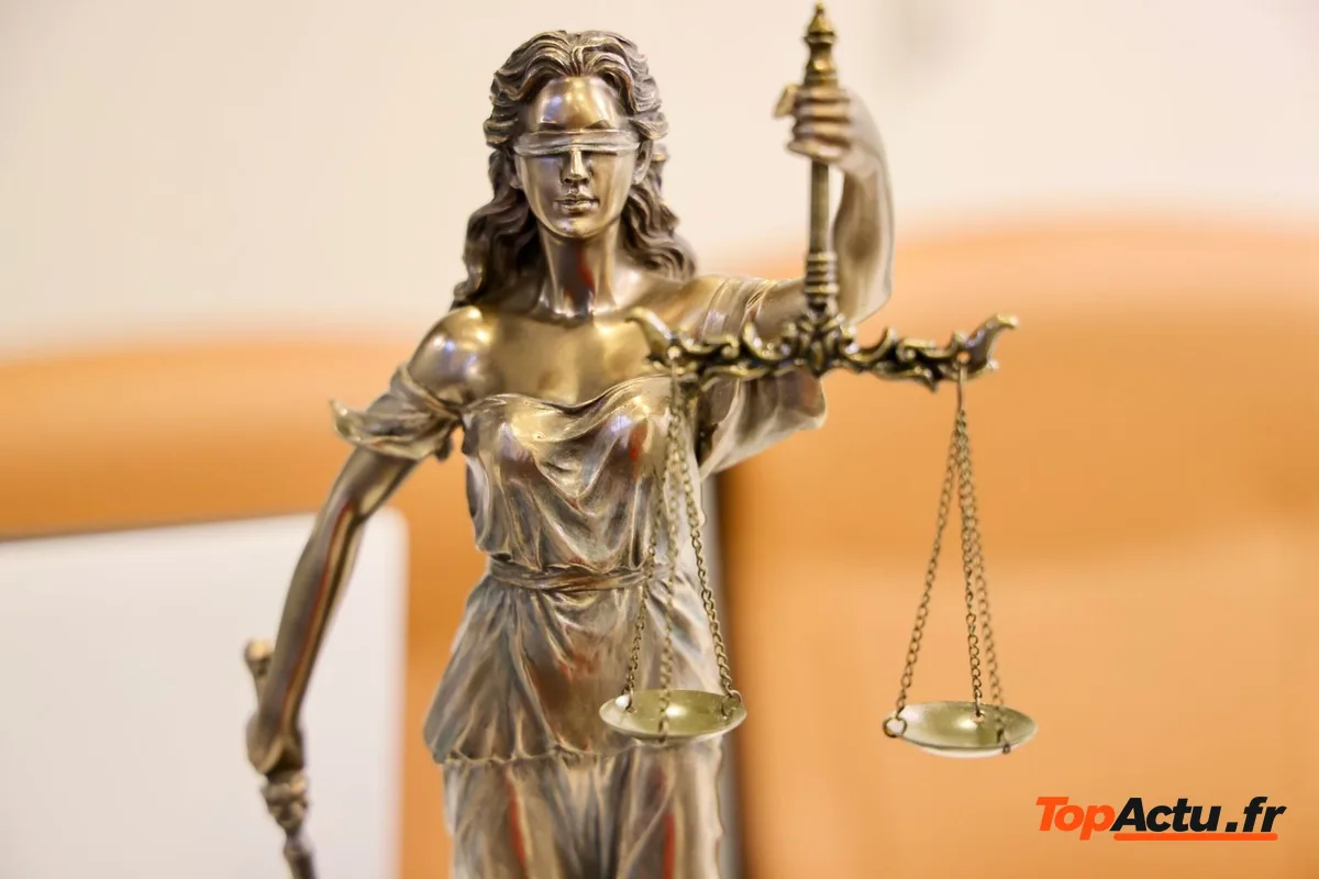 Statue de la justice en bronze tenant une balance, sur un fond clair