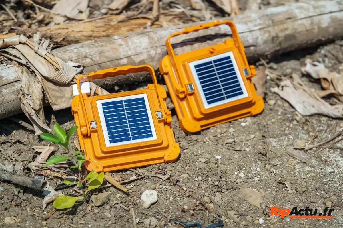 Deux lampes portables orange à panneau solaire posées sur le sol