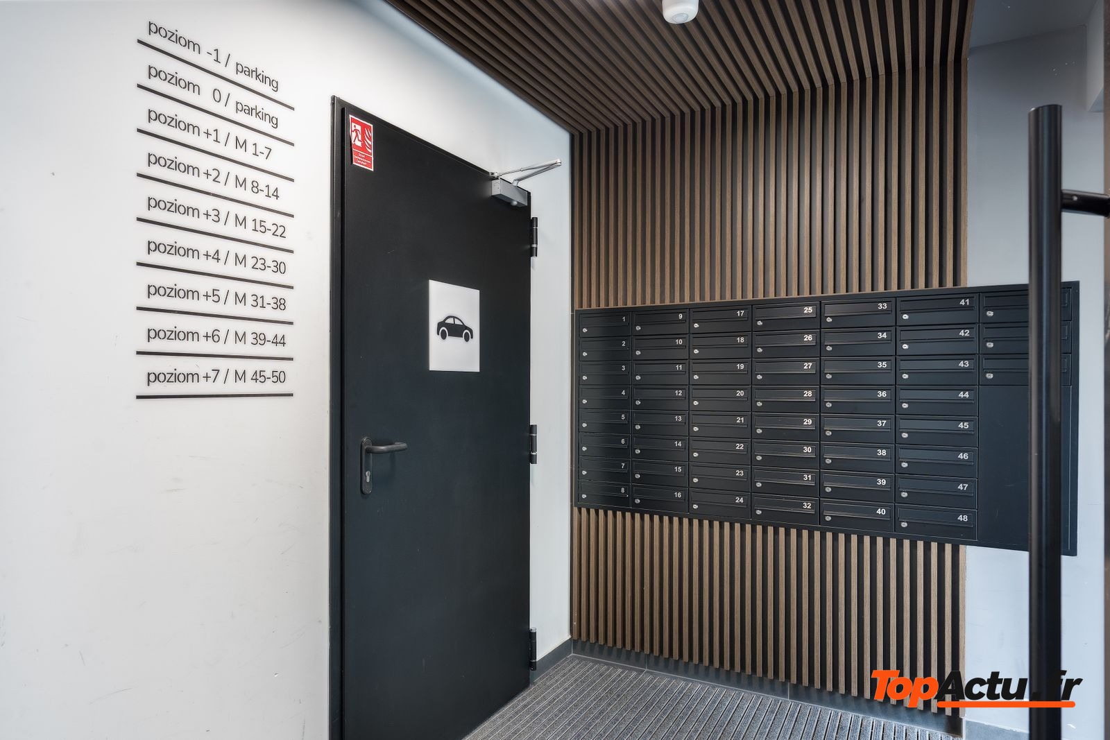 Hall d'immeuble avec des boîtes aux lettres et une porte