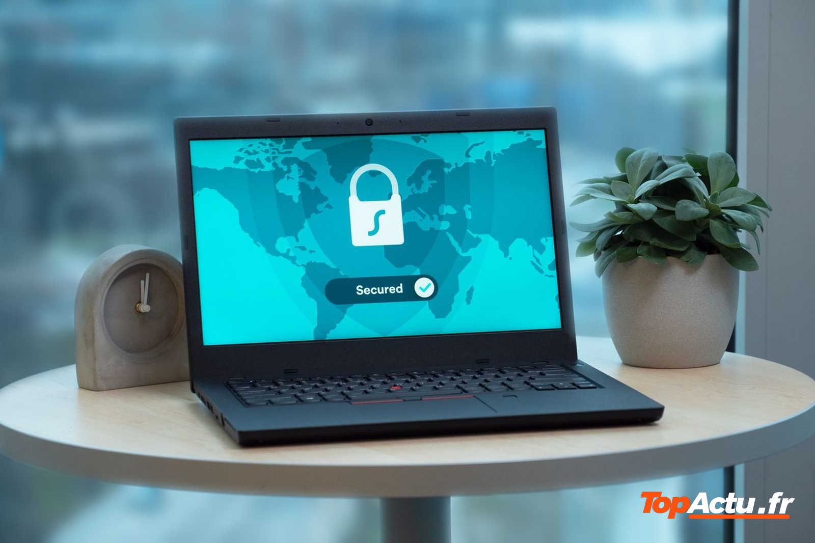 Ordinateur portable affichant un cadenas et la mention « Secured » sur une table près d'une fenêtre