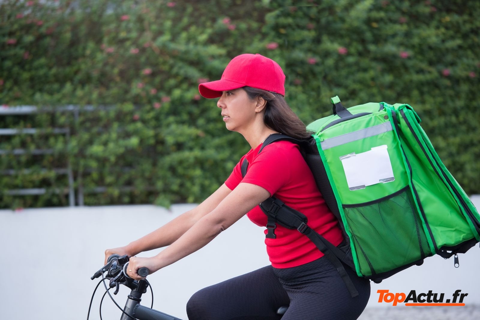 Livreuse à vélo avec un sac isotherme vert