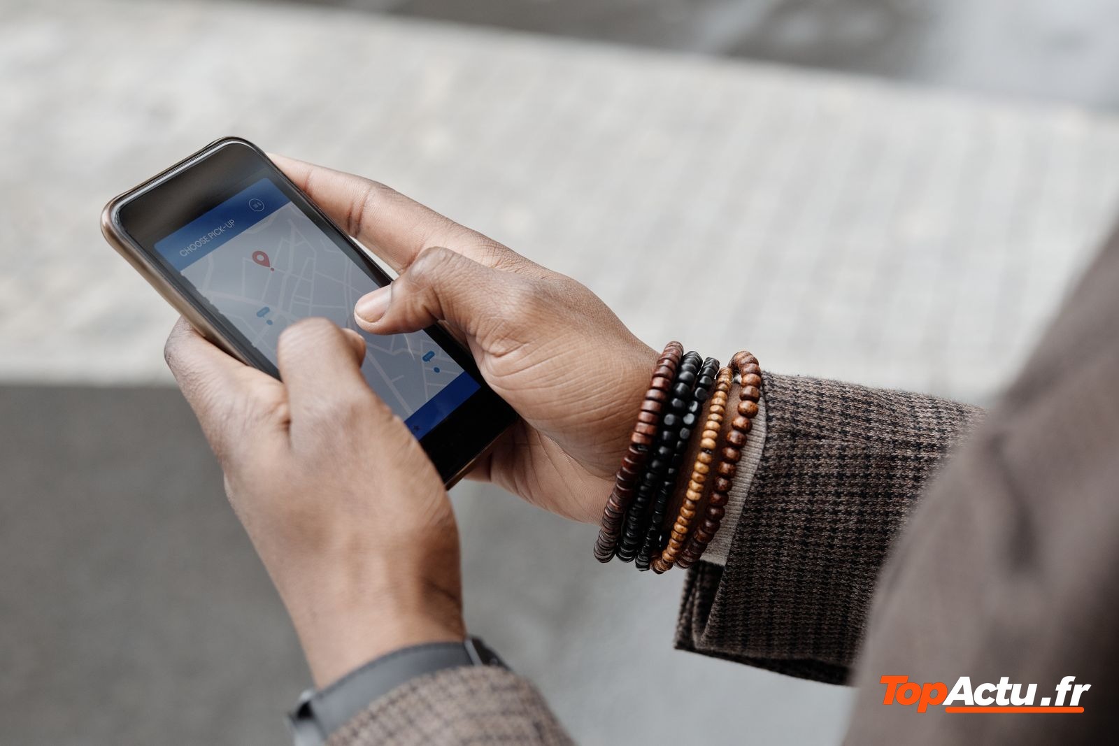 Personne qui consulte un smartphone, des bracelets en perles au poignet