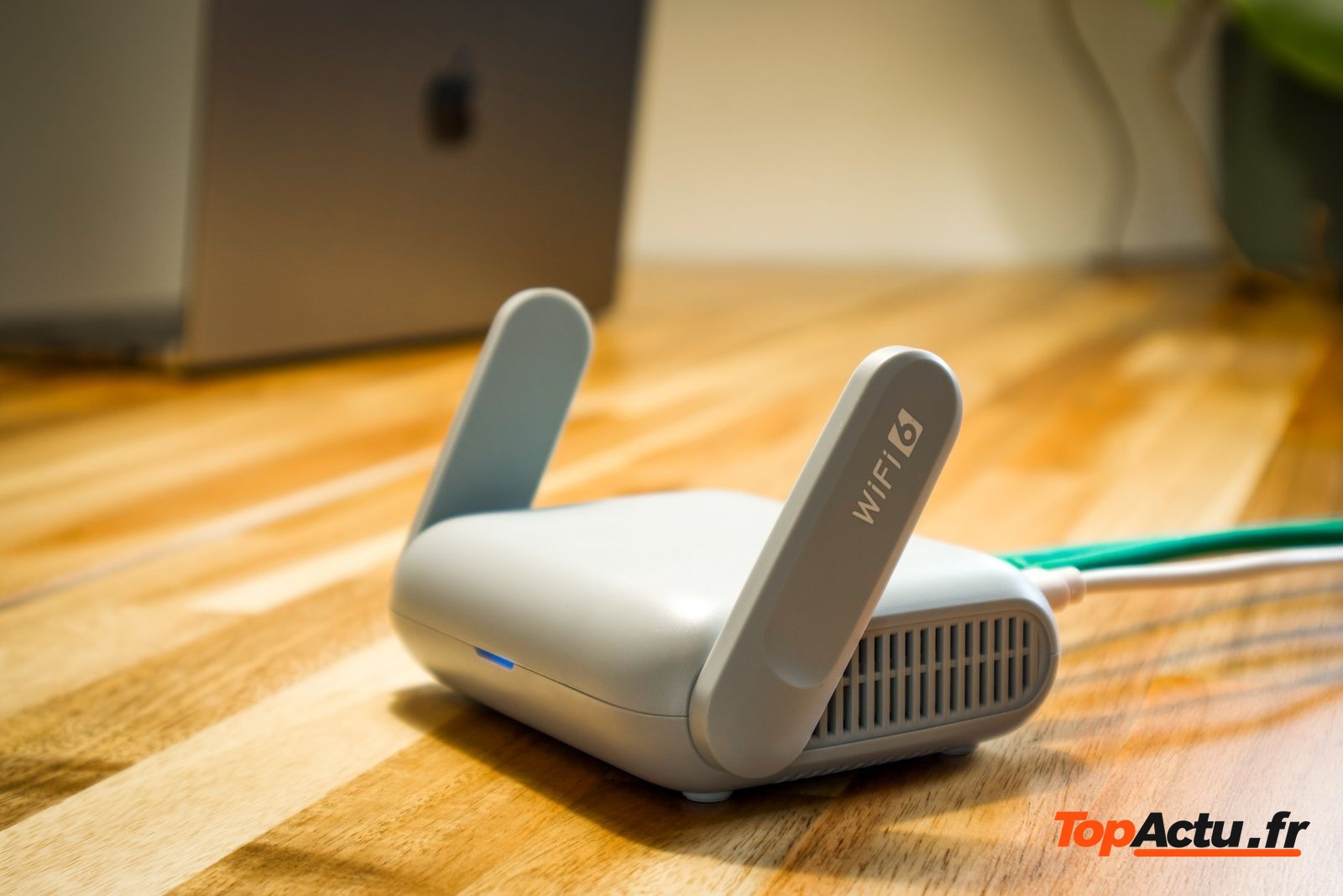 Routeur Wi-Fi blanc posé sur une table en bois