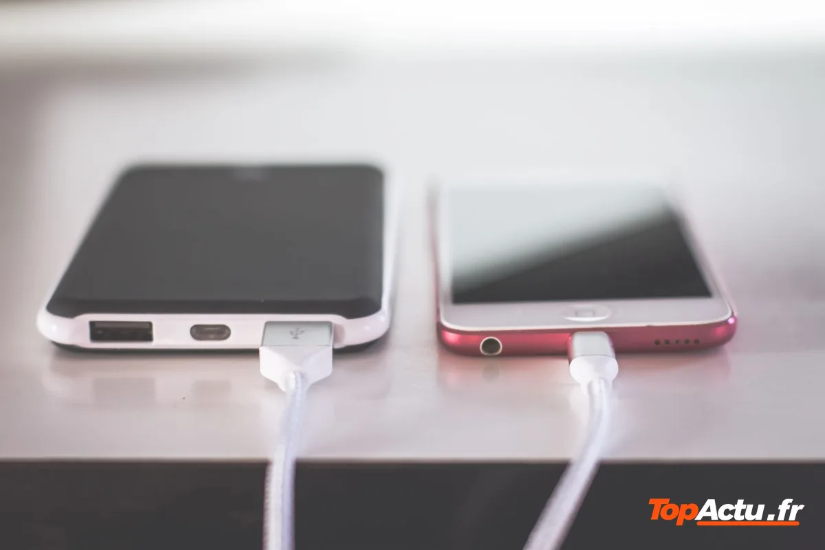 Deux smartphones en charge, branchés à leurs câbles
