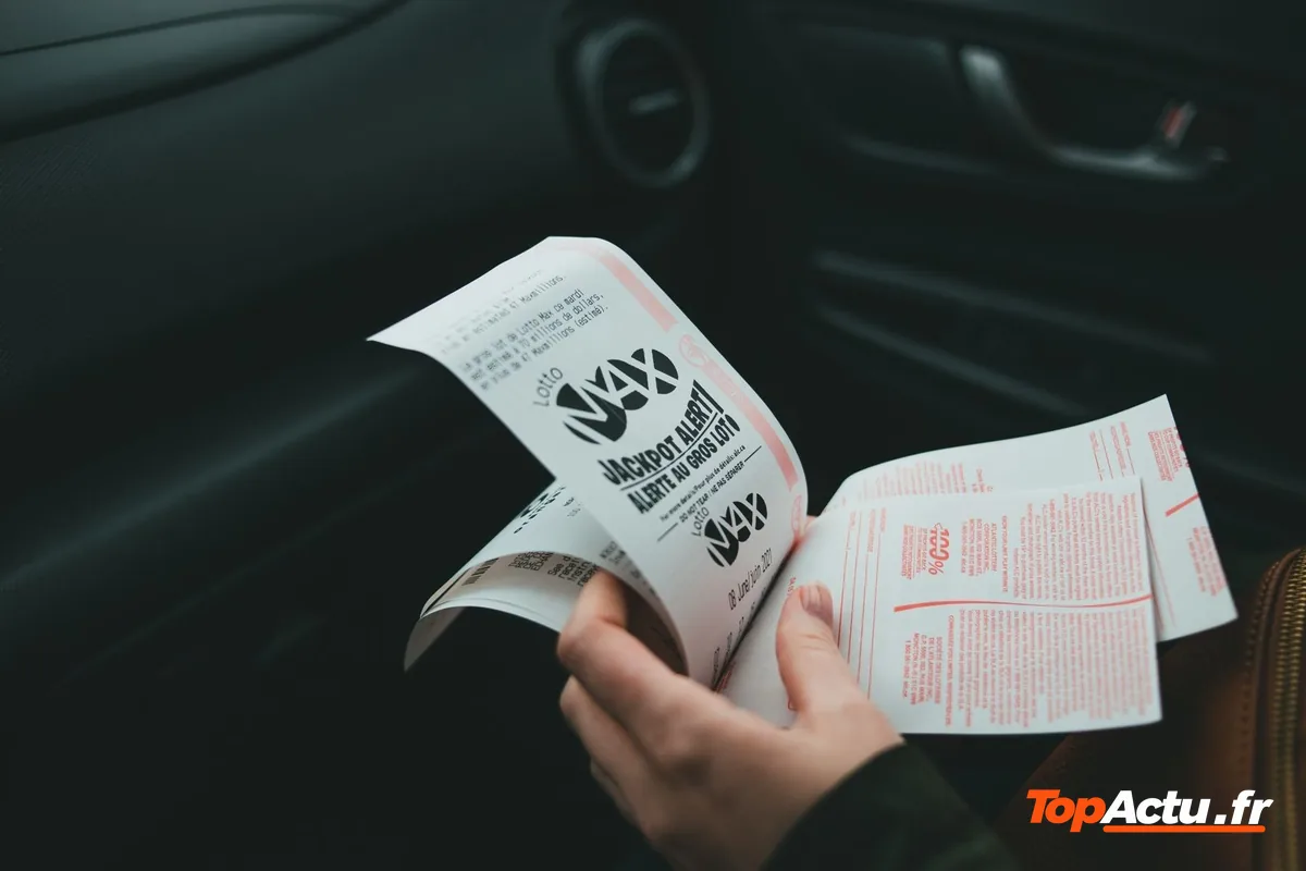 Une main qui tient des billets imprimés dans la pénombre
