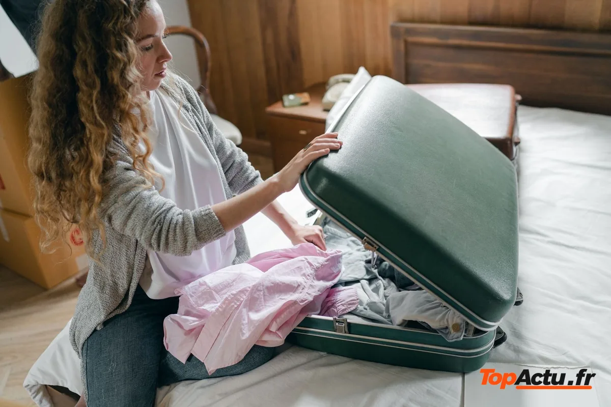 Femme qui prépare sa valise sur un lit